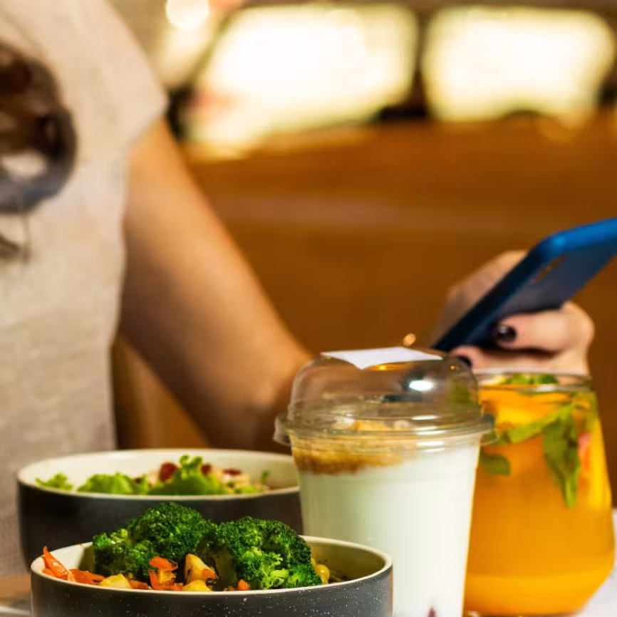 Person using phone and has healthy food in front of them